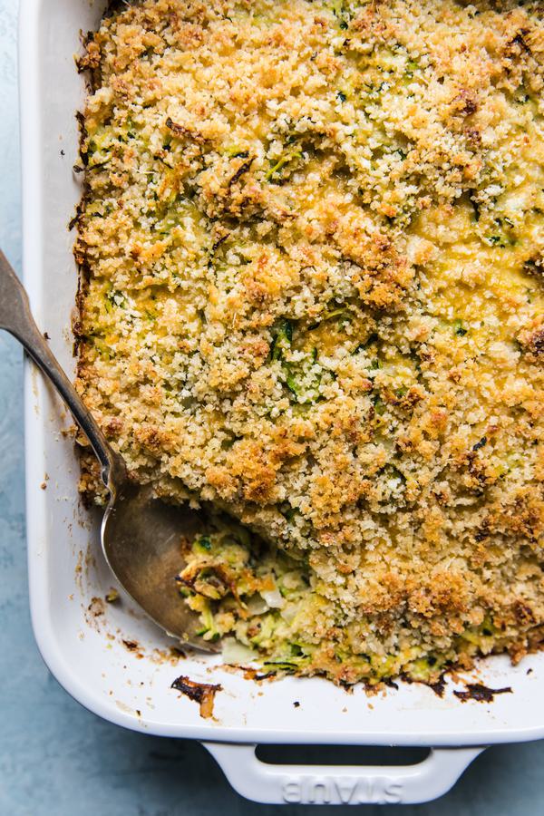 zucchini bake made with onions, dijon, garlic, parmesan, eggs, gruyere cheese, panko bread crumbs and butter
