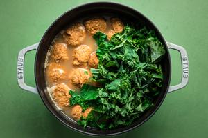 chicken meatballs, pasta and kale in chicken broth in a stock pot