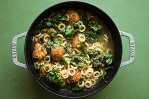 5-ingredient chicken meatball soup with kale and parmesan in a stock pot