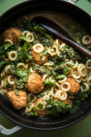5-ingredient chicken meatball soup with kale and parmesan in a stock pot
