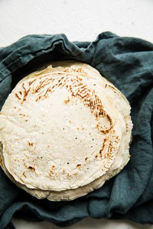 Homemade corn tortillas on a linen towel