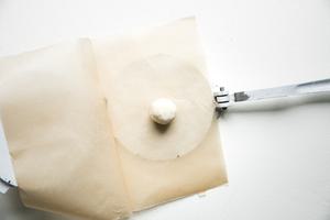 tortilla press with parchment paper and corn tortilla dough