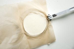 tortilla press with parchment paper and fresh corn tortilla