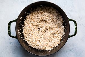 Rice shown toasted in a large pot.
