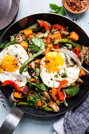 Sweet potato carnitas hash with bell peppers, fried eggs and cilantro