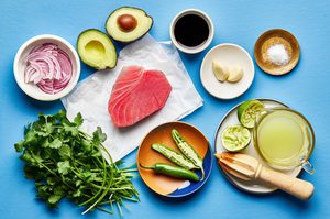 red onion, avocado, raw tuna, soy sauce, garlic, cilantro, lime juice, salt and serrano peppers on a counter for aguachile