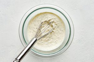 a bowl of homemade creamy parmesan lemon dressing made with lemon juice, olive oil, parmesan, mayo, dijon and spices