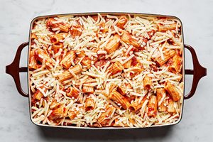 rigatoni with marinara sauce, italian sausage and ground beef topped with shredded mozzarella in a 9x13 casserole dish