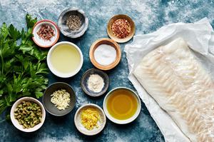 cod filet, spices, parsley, castelvetrano olives, anchovy, garlic, lemon zest & juice & olive oil in bowls on the counter