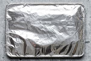 pork ribs covered in homemade dry rub on a baking sheet covered with foil ready to be baked in the oven