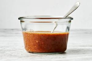 balsamic vinaigrette in a bowl with a spoon made with mustard, honey, balsamic vinegar, olive oil, shallot, salt & pepper