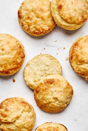 homemade golden fluffy and tender biscuits sliced in half ready to be topped with gravy for the ultimate southern breakfast