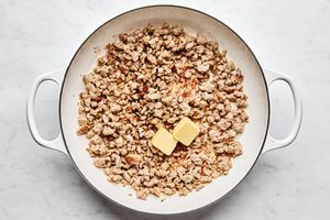butter and sausage cooking in a skillet to make creamy sausage gravy
