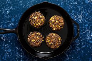 homemade black bean burger patties being cooked in a skillet
