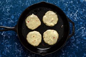 homemade black bean burger patties being cooked in a skillet topped with melted pepper jack cheese