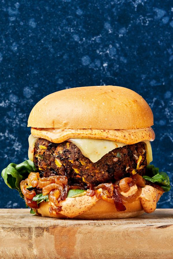 a homemade black bean burger topped with chipotle mayo, caramelized onions, romaine lettuce and pepper jack cheese