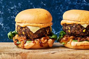two homemade black bean burgers topped with chipotle mayo, caramelized onions, romaine lettuce and pepper jack cheese