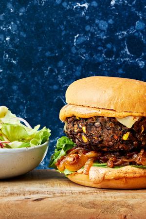 a homemade black bean burger topped with chipotle mayo, caramelized onions, romaine lettuce and pepper jack cheese