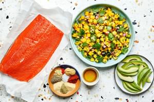 salmon filet, mango salsa, sliced avocado, olive oil and spices in bowls for blackened salmon with mango salsa and avocado