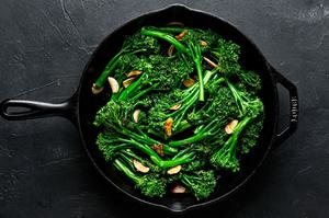 broccolini being cooked in a skillet with olive oil, butter, salt and garlic