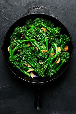 a frying pan full of broccolini cooked in olive oil and butter with salt and garlic and sprinkled with flaky salt