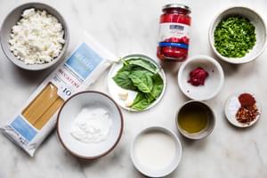 bucatini, feta, garlic, greek yogurt, olive oil, roasted red peppers, tomato paste, spices, basil, cream & parsley in bowls