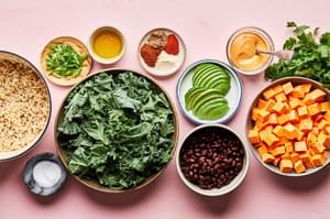 brown rice, kale, sweet potatoes, black beans, avocado and vegan cashew cheese sauce in bowls to make homemade buddha bowls