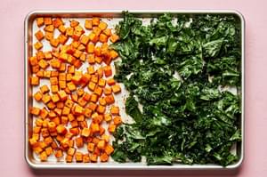 roasted sweet potatoes seasoned with paprika, chili powder, garlic powder, sugar & salt and kale on a baking sheet