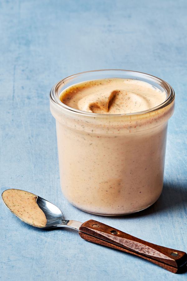 Homemade burger sauce made with mayo, ketchup, spices, lime juice & pickle juice, in a jar next to a spoon full of sauce.
