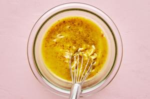 Homemade Balsamic Vinaigrette made with white balsamic vinegar being whisked in a glass bowl