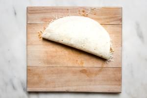 a flour tortilla folded in half filled with mozzarella, caramelized onions, roasted butternut squash and black beans