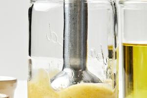 egg yolks, anchovies, garlic, lemon juice & salt being blended together in a glass jar with an immersion blender