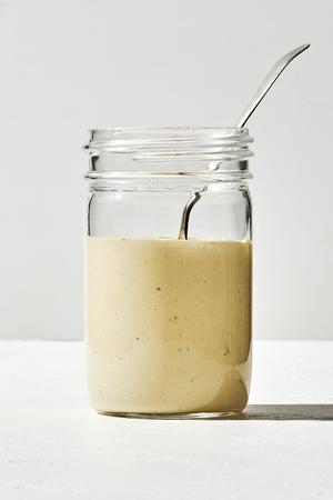 homemade Caesar dressing made with egg yolk, anchovy, garlic, lemon, salt, avocado oil Worcestershire and pepper in a jar