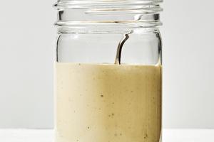 homemade Caesar dressing made with egg yolk, anchovy, garlic, lemon, salt, avocado oil Worcestershire and pepper in a jar
