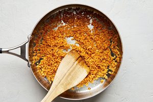panko breadcrumbs being toasted in olive oil in a skillet for Caesar salad
