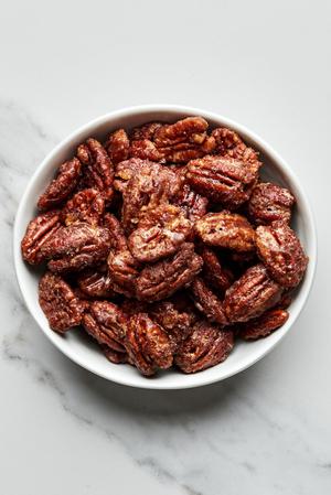 a bowl of homemade candied pecans made with brown sugar, cinnamon, salt and cayenne pepper