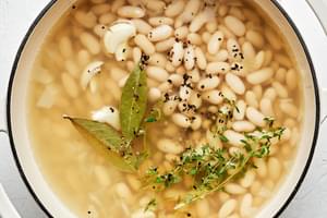 dried cannellini beans, water onion sautéed in olive oil, bay leaves, thyme, garlic, salt & pepper cooking in a pot