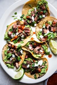 homemade carne asada tacos with onion, lime, and cilantro