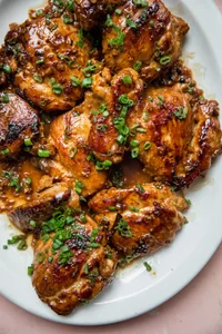 homemade chicken adobo on a serving platter topped with chopped green onions