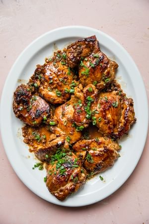 a platter of homemade chicken adobo sprinkled with green onions