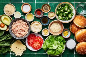 ground chicken, spices, mayo, jalapeños, avocado, lettuce, tomato, pepper jack, basil in bowls for making chicken burgers