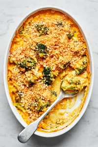 chicken divan in a casserole dish with a serving spoon made with chicken, broccoli, cheese and topped with panko