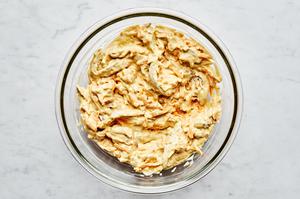 salt, cream of chicken soup, sour cream, milk, garlic & onion powders, curry powder, bouillon, chicken, & cheese in a bowl