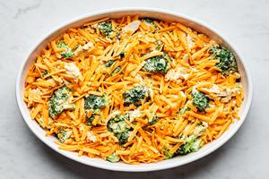 chicken divan in a casserole dish topped with shredded cheese