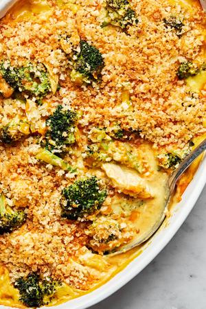 chicken divan in a casserole dish with a serving spoon made with chicken, broccoli, cheese and topped with panko