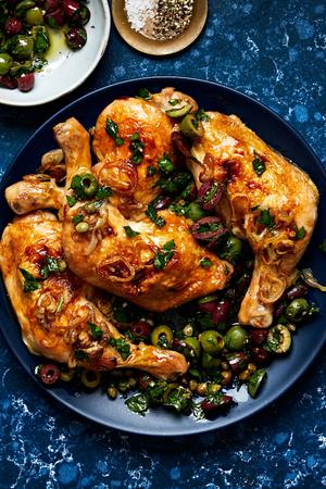Chicken Quarters with Shallots and Olive Salad with capers, parsley, garlic & Italian seasoning on a serving platter