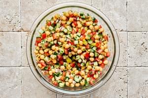Chickpea Salad with cucumbers, tomatoes & red onion tossed with homemade Italian dressing in a large mixing bowl
