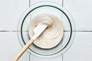 crema in a bowl being stirred with a spatula made with sour cream, taco seasoning, lime juice and heavy cream