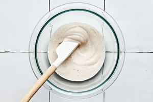 crema in a bowl being stirred with a spatula made with sour cream, taco seasoning, lime juice and heavy cream