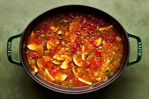 onion, bell pepper, zucchini, black beans, chipotle chilis, creamed corn, chicken broth and spices cooking in a soup pot